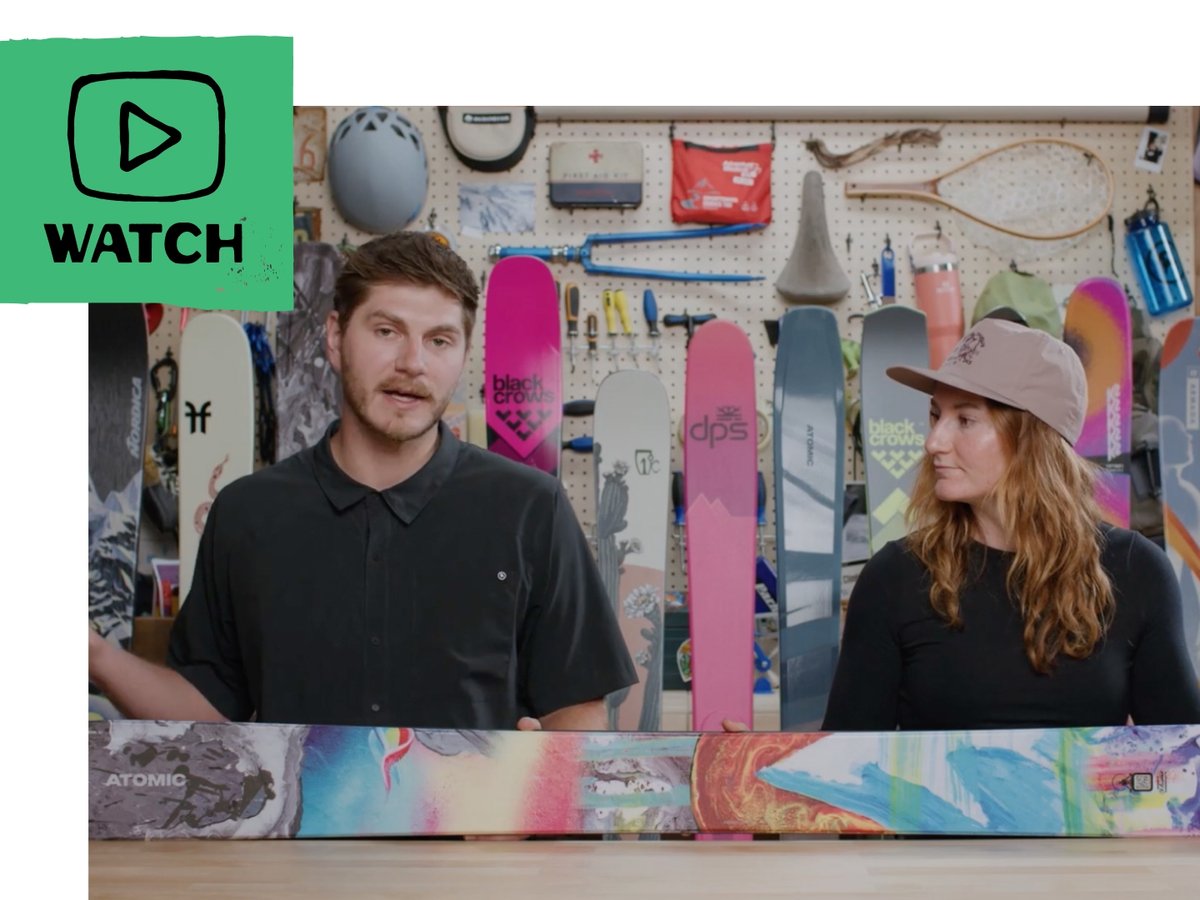 A Gearhead talking about skis while sitting at a ski tech bench.  