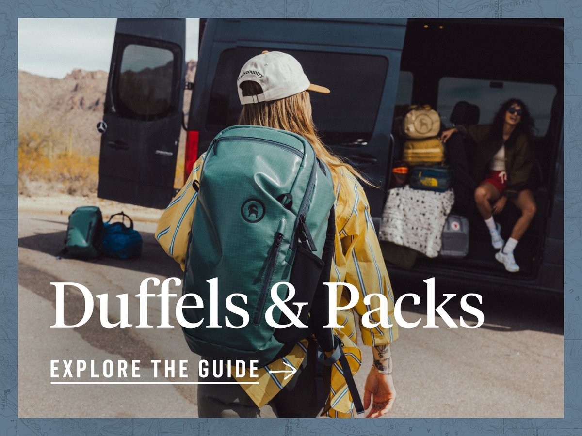 A woman with a green backpack walks towards another woman sitting in a van. The words, “Duffels & packs, explore the guide” appear under her.