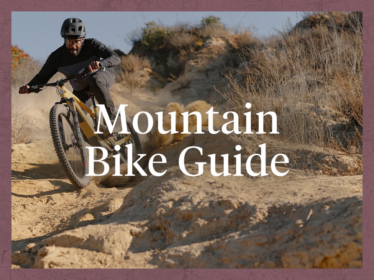 A man rides down a dusty desert trail on a yellow mountain bike. The words, “Mountain Bike Guide, Ride Ready: Bikes Apparel & Gear” appear next to him.