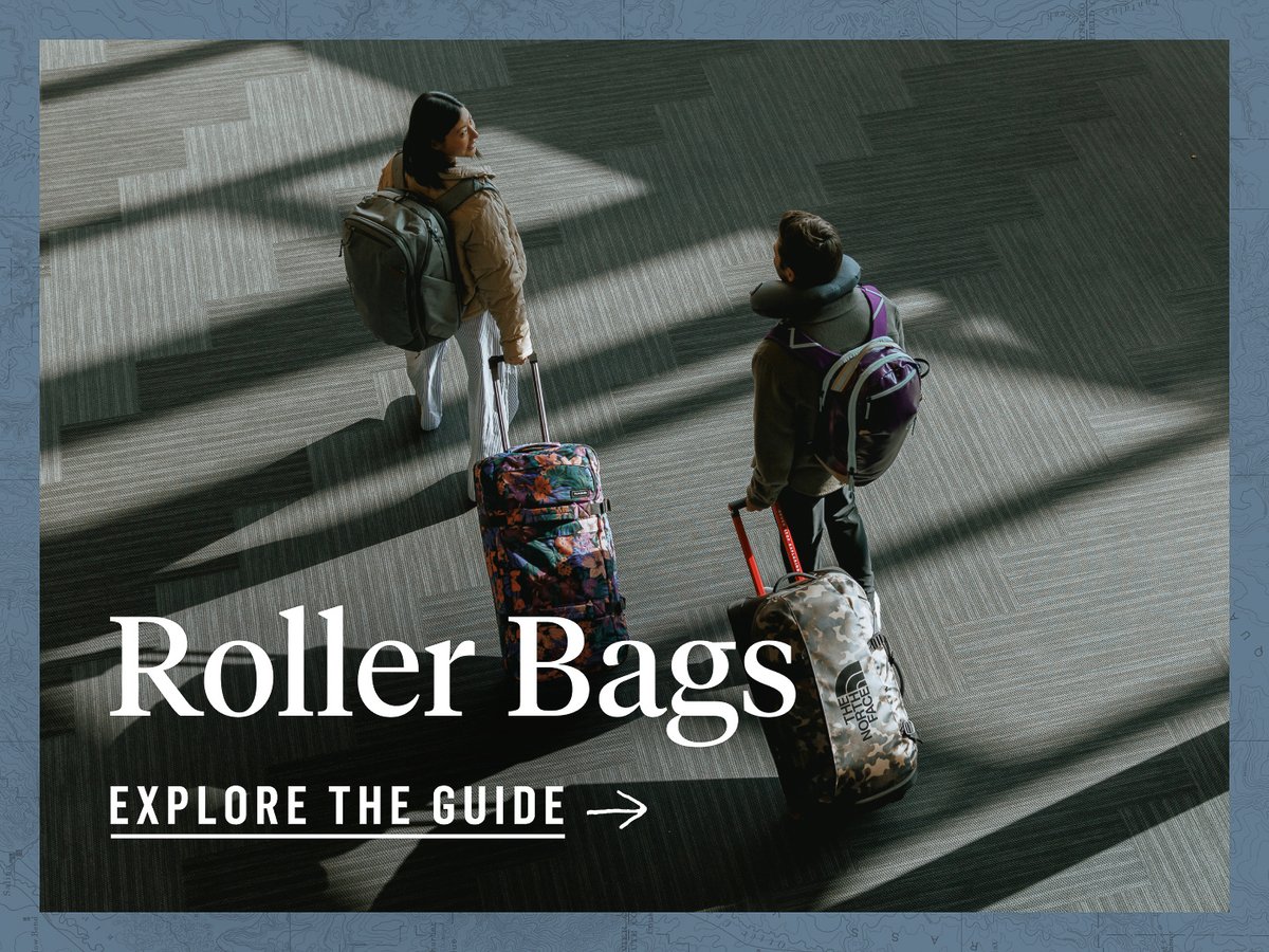 Two people walk through an airport terminal. The shot is from over the shoulder. They are carrying backpacks and pulling roller bags behind them. The words, “Roller bags, explore the guide” appear under them.